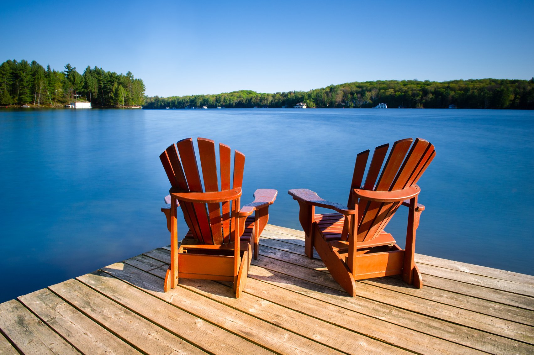 Adirondack chairs on a wooden pier